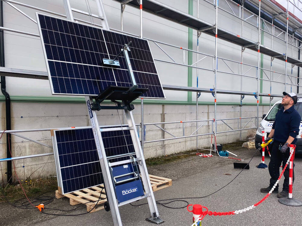 Solcellenpanel fraktes fra bakke til tak med Jamax Böcker toplift med tilpasset solcelleplatform.